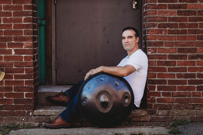 Gabe Cabral posing with his handpan instrument